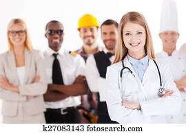 wenn, ich, wachsen, herauf, ich, wille, sein, a, arzt., schön, jung, weiblicher doktor, beibehaltung, verschränkte arme, und, lächeln, während, menschengruppe, in, verschieden, berufe, stehen, in, dass, hintergrund