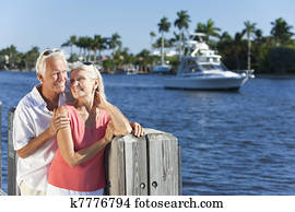 Happy Senior Couple By River or Sea with Boat Happy Senior Couple By River or Sea with Boat