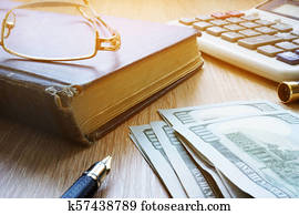 Pension savings. Money, glasses and pills on a desk.