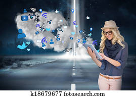 Stylish blonde using tablet pc with app icons and cloud