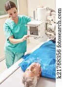 Xray machine. Female doctor analyzing senior male