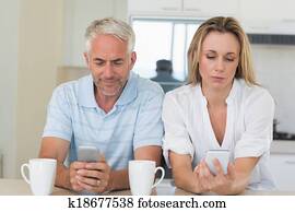 Distant couple sitting at the counter texting and not talking
