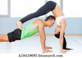 Man and woman exercising. Young loving couple making exercising in gym