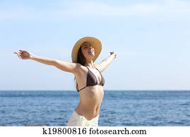Happy woman breathing fresh air on the beach raising arms Happy woman breathing fresh air on the beach raising arms