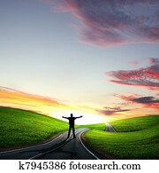 Man walking away at dawn along road Man walking away at dawn along road