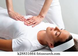 Therapist pressing with hands on womans chest at reiki session. Therapist pressing with hands on womans chest at reiki session.