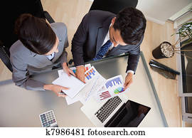 Focused sales persons studying statistics Focused sales persons studying statistics