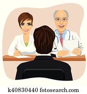 man sitting opposite mature doctor with assistant sitting at a office desk