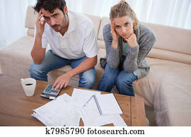 Worried couple doing their accounting Worried couple doing their accounting