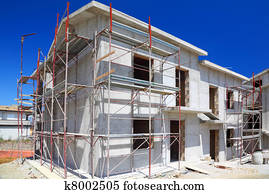 Construction of building of new two-story white concrete house with stairs and balcony