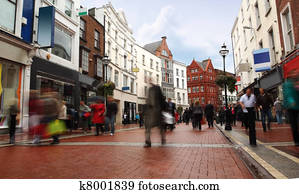 people quickly going on small, narrow street in cloudy weather