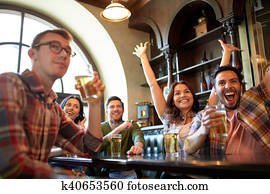 friends with beer watching football at bar or pub friends with beer watching football at bar or pub
