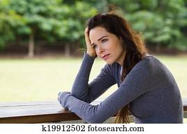 Sad depressed woman sitting outdoors Sad depressed woman sitting outdoors