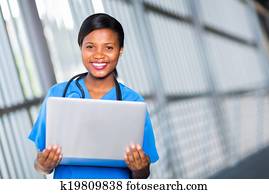 african american female doctor holding laptop computer