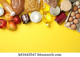 Different food on yellow background, top view. Donation concept