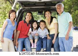 Extended family sitting in tailgate of car