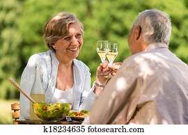 Happy senior citizens clinking glasses