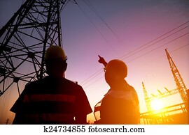 two worker watching the power tower and substation with sunset b two worker watching the power tower and substation with sunset b