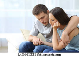Sad couple comforting each other at home Sad couple comforting each other at home