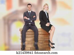 Business People Sitting On Stacked Coins