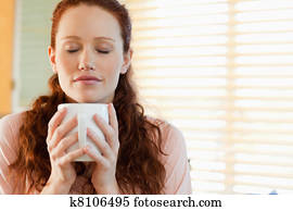 Woman enjoys the smell of her coffee