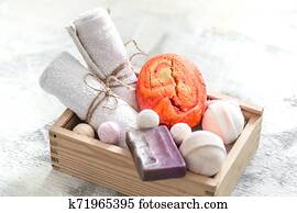 Beauty care products in wooden box. soap, towel with orange bath bomb. Spa or personal hygiene concept Beauty care products in wooden box. soap, towel with orange bath bomb. Spa or personal hygiene concept