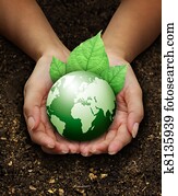 human hands holding green earth