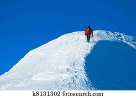 Lone male mountain climber on summit