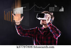 Man wearing virtual reality goggles. Studio shot, black backgrou