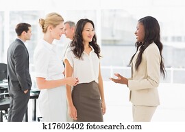 Businesswomen speaking together in conference room Businesswomen speaking together in conference room