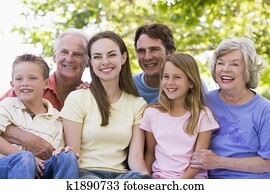 Extended family sitting outdoors smiling Extended family sitting outdoors smiling