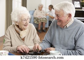 Couple Playing Dominoes At Day Care Centre Couple Playing Dominoes At Day Care Centre