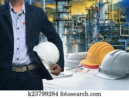 engineering man standing with white safety helmet against oil r engineering man standing with white safety helmet against oil r