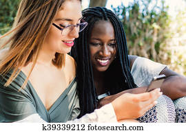 Diversity teen girls looking at smart phone together.