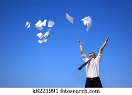 business man relaxing and throwing white papers  to the blue sky