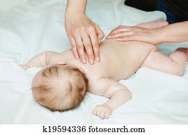 Masseur massaging a child baby Masseur massaging a child baby