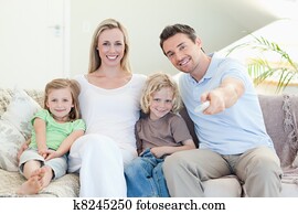 Family watching television on the sofa