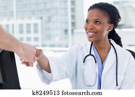 Female doctor shaking a hand