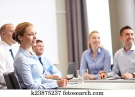 group of smiling businesspeople meeting in office