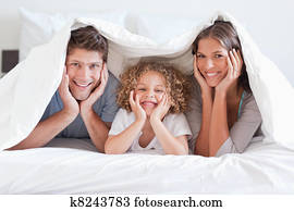 Happy family posing under a duvet Happy family posing under a duvet