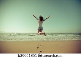 mujer feliz, saltar, en la playa