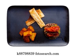 traditional spanish rissole with fried potato served on black plate