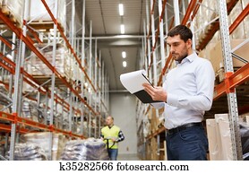 businessman writing to clipboard at warehouse businessman writing to clipboard at warehouse