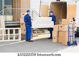 Movers Carrying Sofa Outside Truck On Street