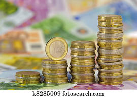 stacked euro coins on banknotes