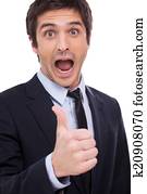 Thumb up for success! Happy young man in formalwear showing his thumb up and keeping mouth open while standing isolated on white background 