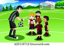 Little kids in soccer field listening to their coach Little kids in soccer field listening to their coach