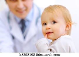 Portrait of baby and pediatrician doctor in background Portrait of baby and pediatrician doctor in background
