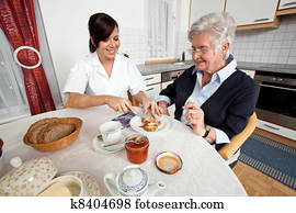 nurse helps elderly woman at breakfast nurse helps elderly woman at breakfast