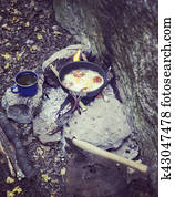 Cooking breakfast on a campfire at a summer camp. Cooking breakfast on a campfire at a summer camp.